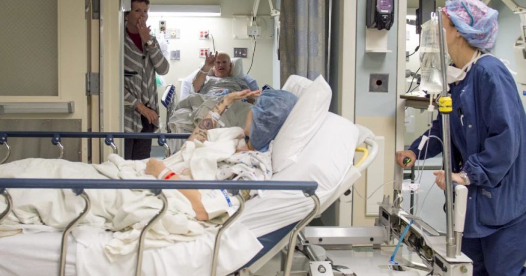 A kidney donor waves to the recipient on her way to the operating room.