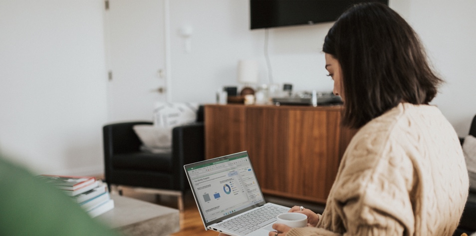 A woman attends a virtual medical conference from a laptop in her living room.